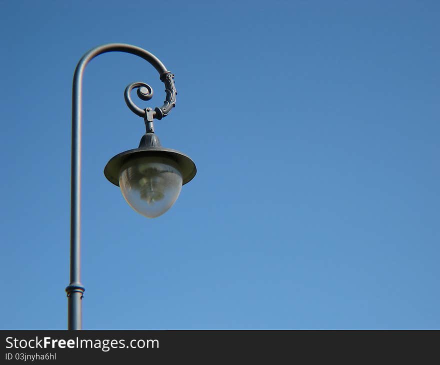 Street lantern against the blue sky without clouds