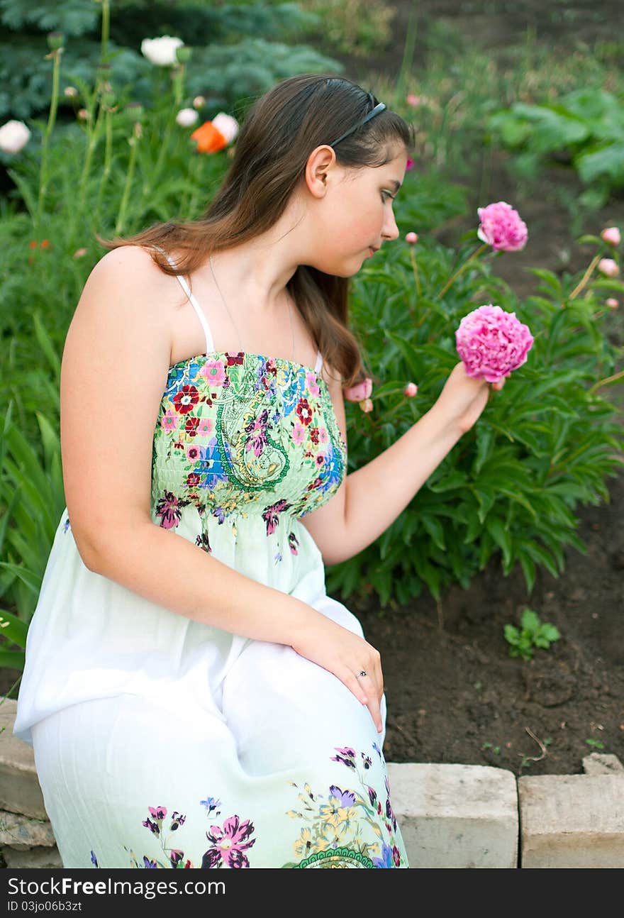 Girl against pink peony flowers