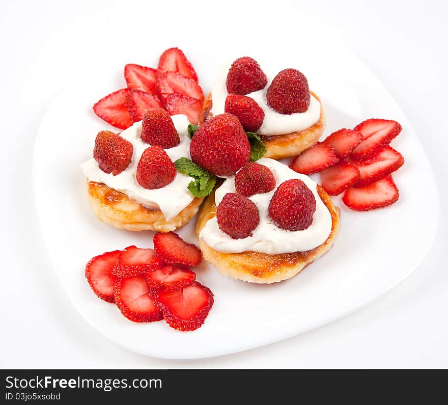 Pancakes with strawberries and cream on white plate