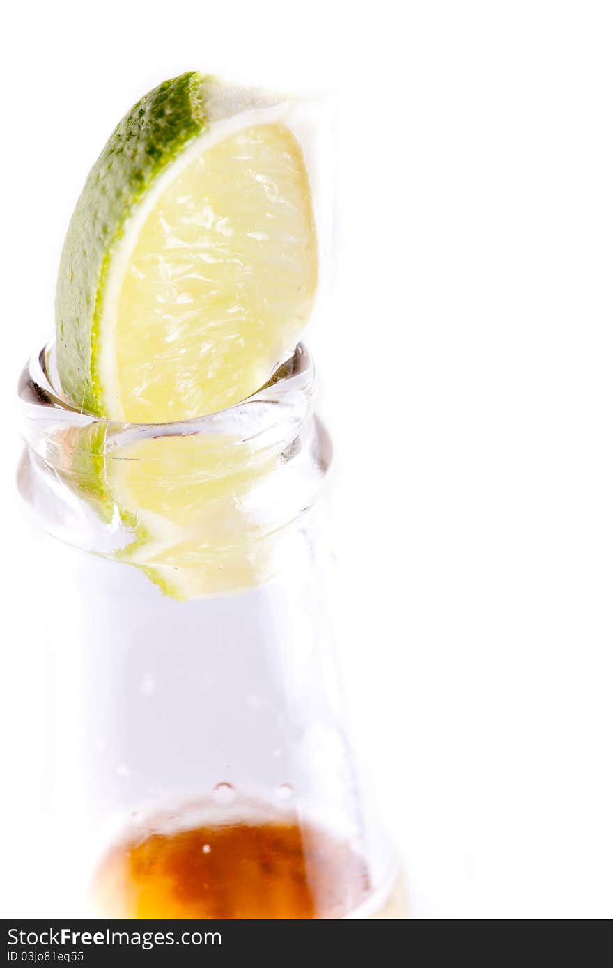 Beer bottle with lime wedge in white background