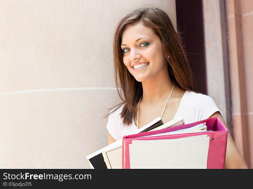 A pretty young college or high school age girl with study materials. A pretty young college or high school age girl with study materials