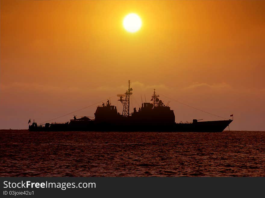 Sunset with a battleship anchored