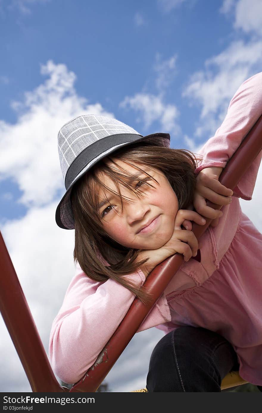 A young girl with a stylish hat in an outdoor setting. A young girl with a stylish hat in an outdoor setting.