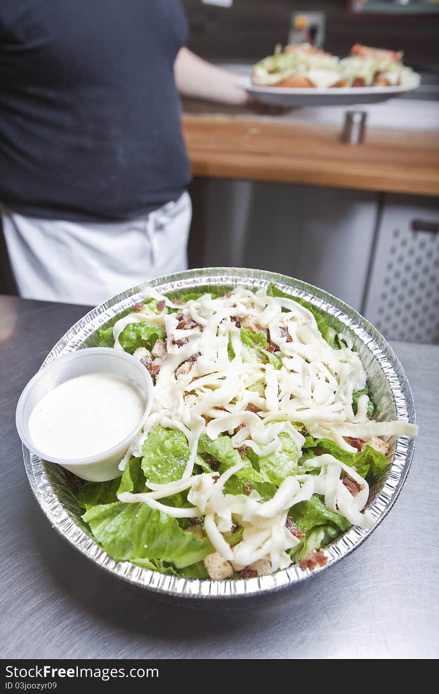 Waiter with take out caesar salad