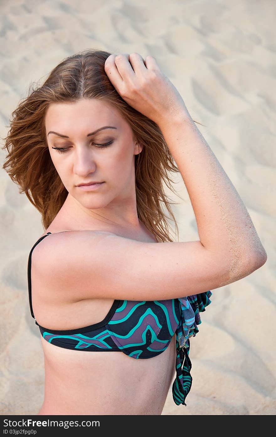 Woman in a swimsuit on a sandy background