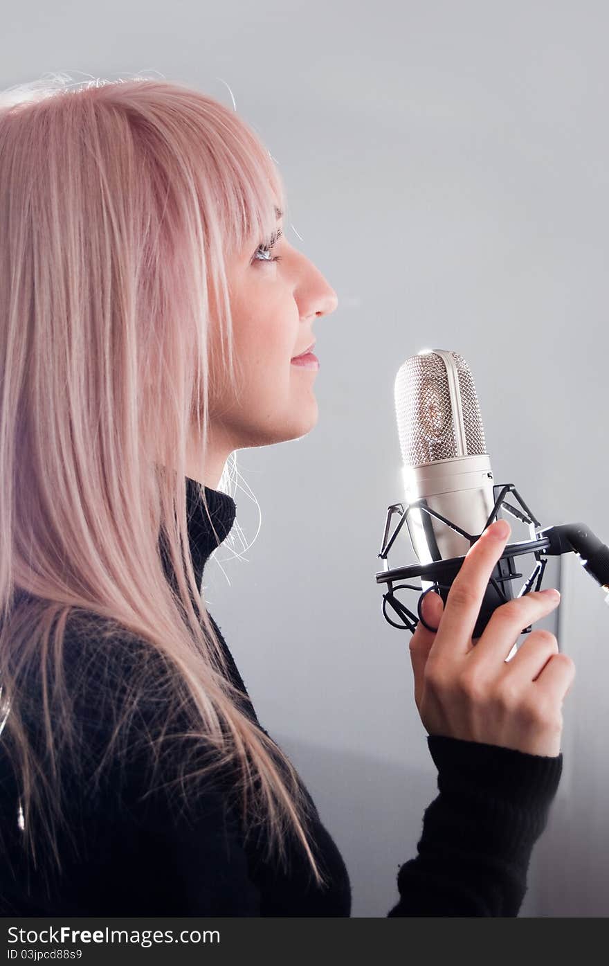 Portrait of blonde girl at the microphone