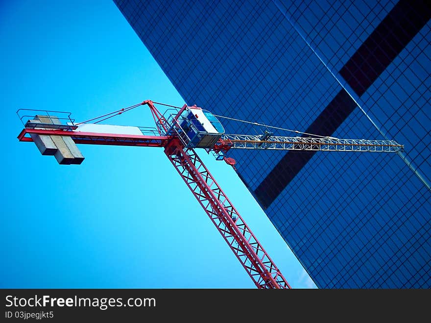 Tower crane on glass skyscraper background