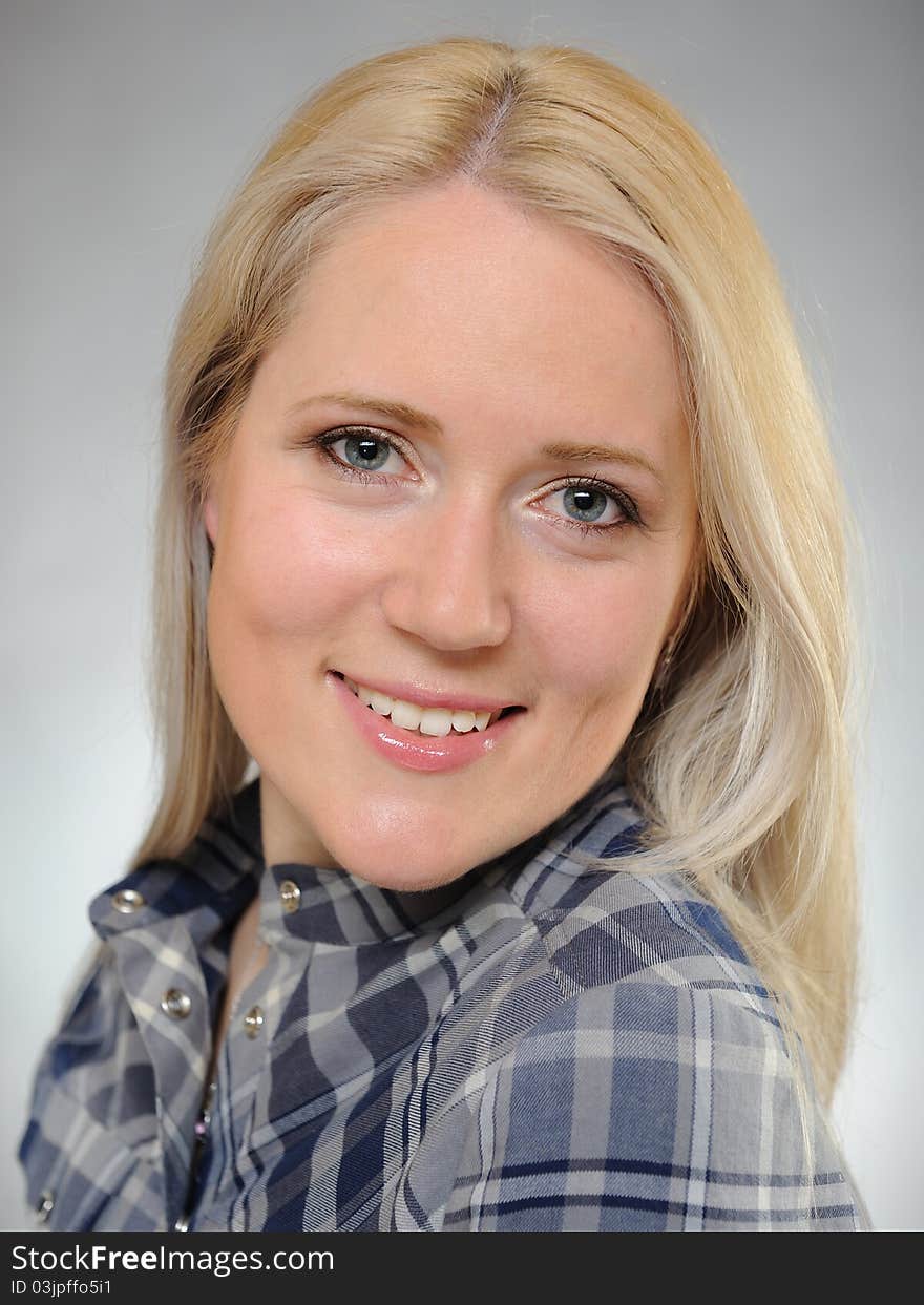 Portrait of young pretty smiling woman in a shirt