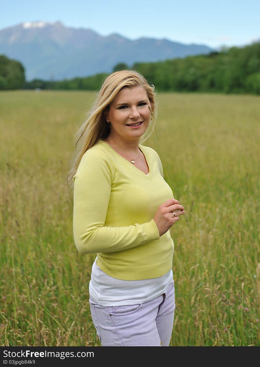 Beautiful natural woman with pure healthy skin outdoors on spring field. Switzerland. Beautiful natural woman with pure healthy skin outdoors on spring field. Switzerland