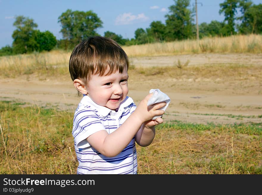 Child after an active game on meadow cleans hands. Child after an active game on meadow cleans hands