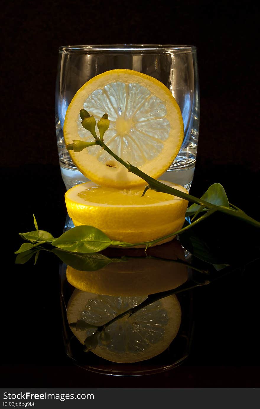 Lemon composition on a black background with reflection on the bottom. Lemon composition on a black background with reflection on the bottom.