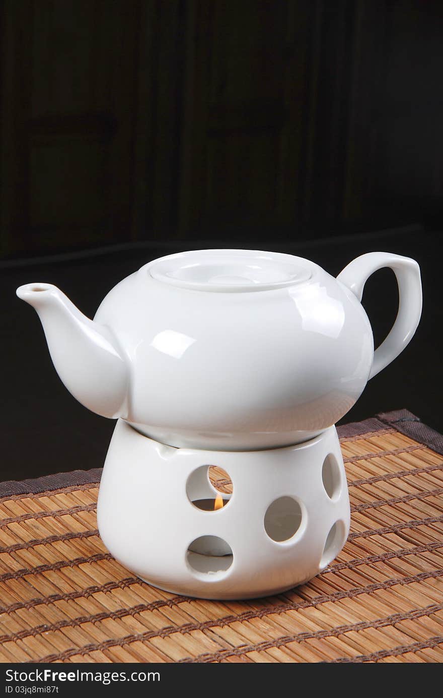 White teapot with candle on table