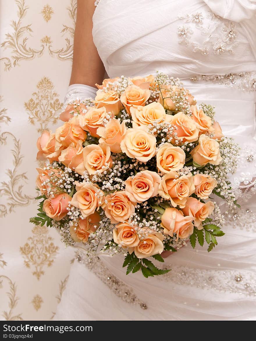 Beautiful bride holding orange bouquet detail