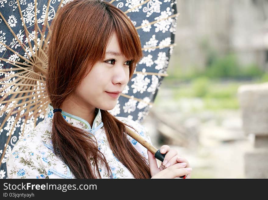 Charming Chinese girl holding the umbrella smiling outdoor. Charming Chinese girl holding the umbrella smiling outdoor.