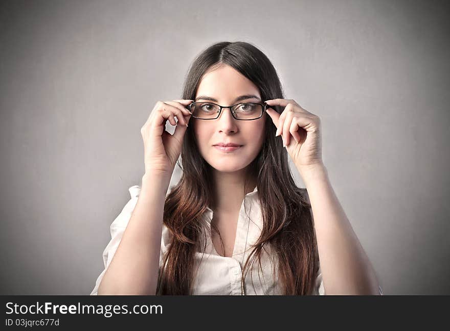 Young businesswoman putting on a pair of glasses