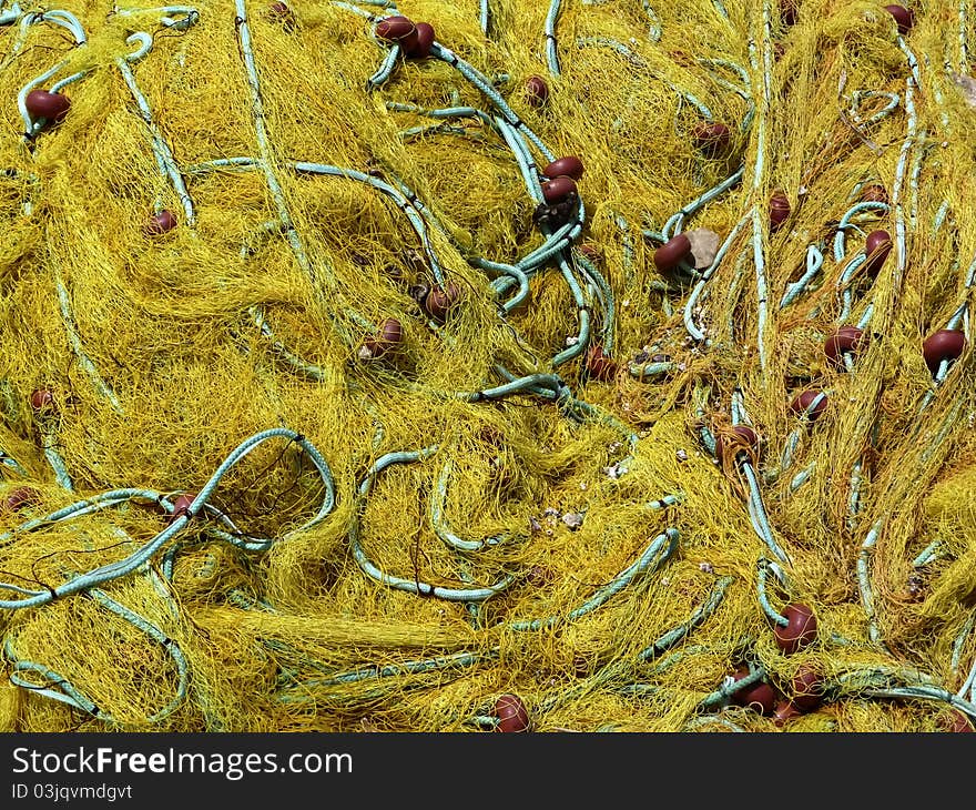 Yellow fishing net with blue nylon rope at local greece marina.