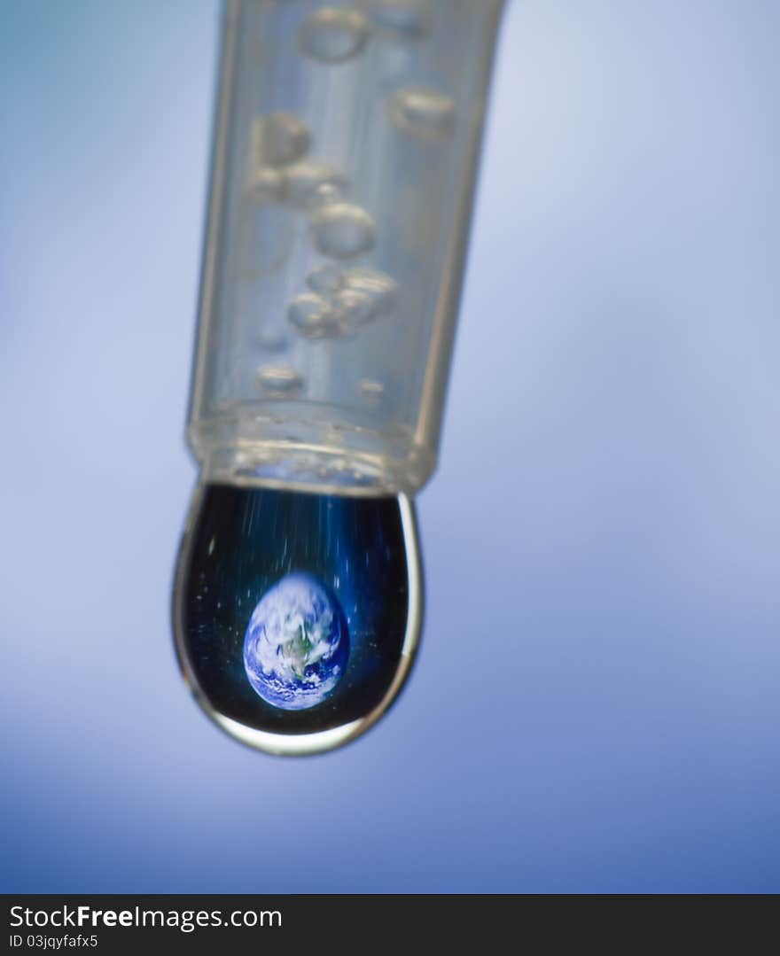 Earth dripping in water drop from eye dropper.