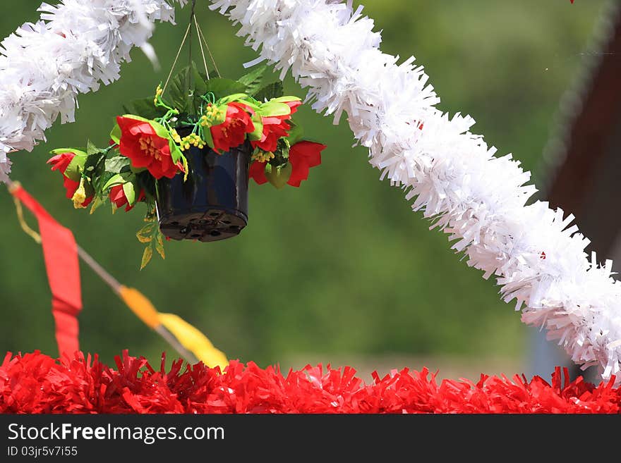 Vase of flowers hanging on top of s.joao festival's decorations