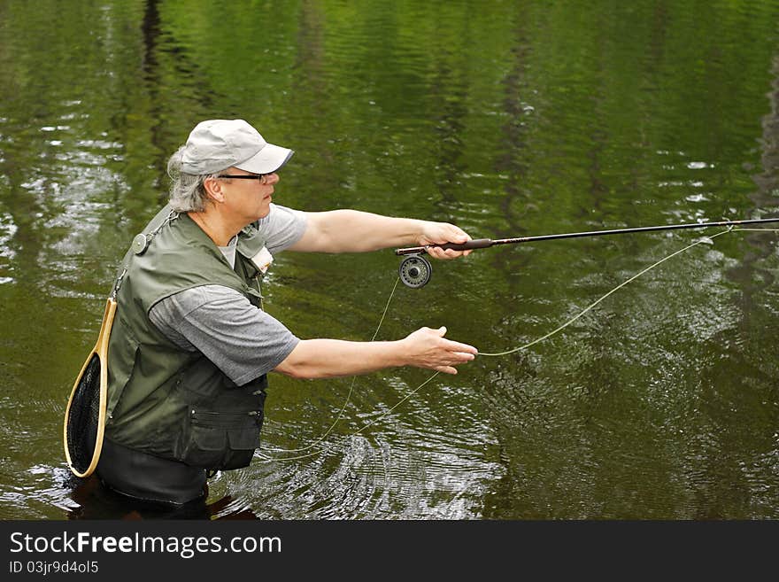 A fly fisherman casts his line. A fly fisherman casts his line