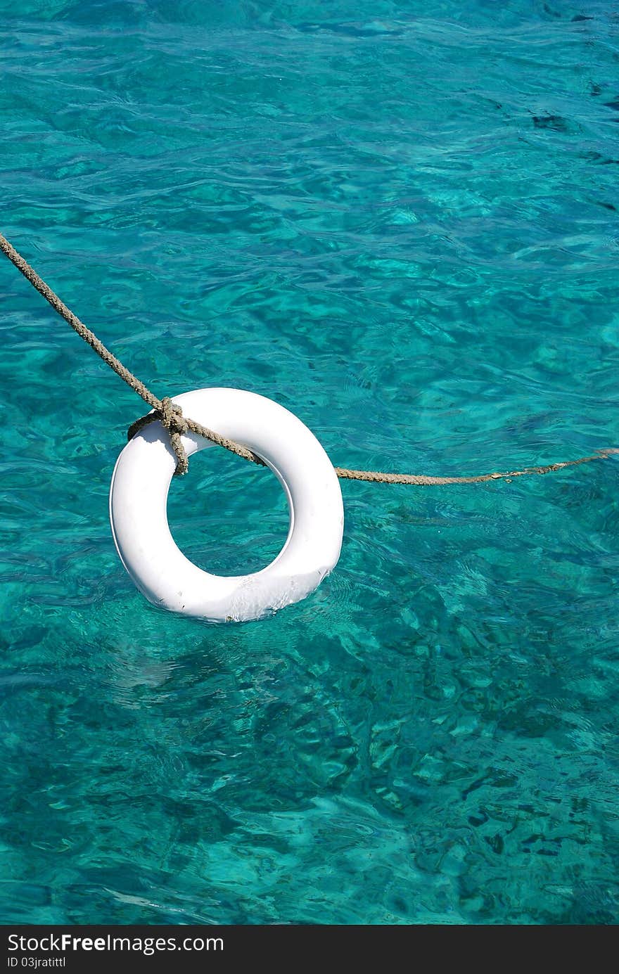 Clasic lifebelt hanging from a rope. On a boat in Catalina island, in Dominican Republic. Clasic lifebelt hanging from a rope. On a boat in Catalina island, in Dominican Republic.