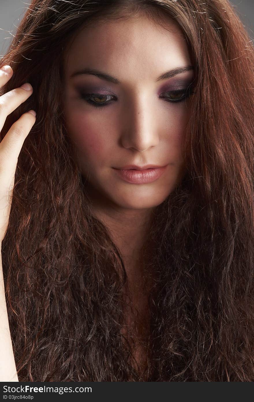 Portrait of beautiful young woman with make-up on grey background