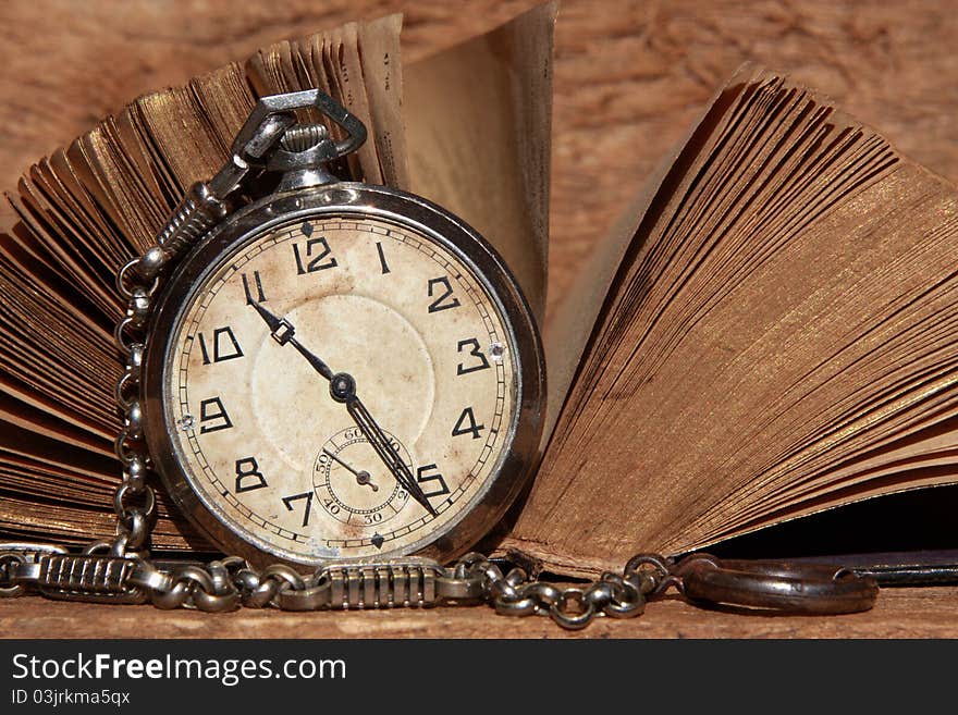 An antique pocket watch leaning against the the worn pages of an old Bible (with a published date of 1884). An antique pocket watch leaning against the the worn pages of an old Bible (with a published date of 1884).