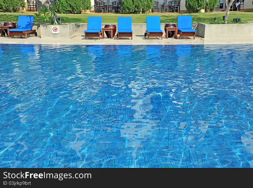 Poolside Benches With Swimming Pool In The Foreground