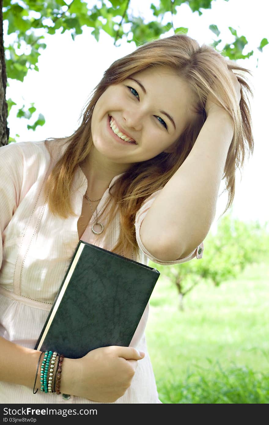 Teenager girl with book in park