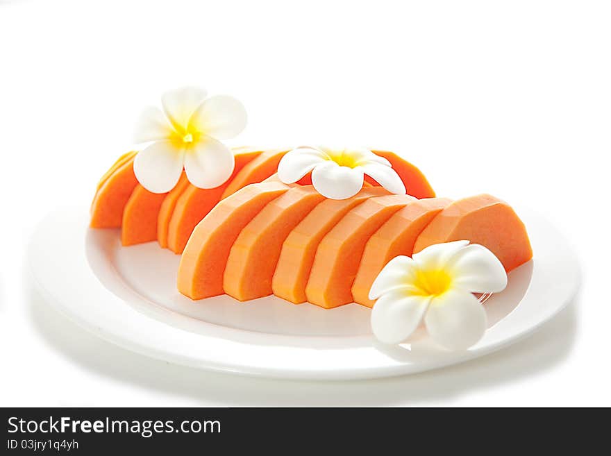 Freshly Diced Papaya with white flowers on white plate isolated on white background. Freshly Diced Papaya with white flowers on white plate isolated on white background