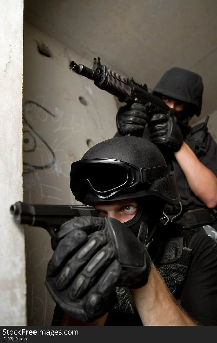 Soldiers in masks targeting from covered position