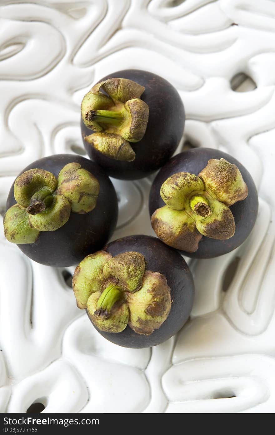 Mangosteens on white bowl