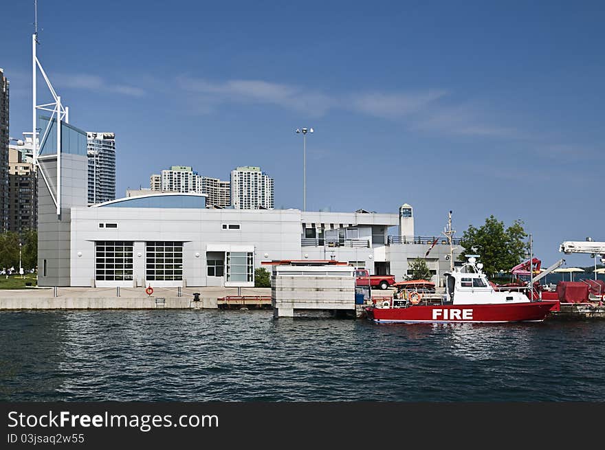 Marine fire station located on the lakefront with a patrol boat docked in foreground. Marine fire station located on the lakefront with a patrol boat docked in foreground.