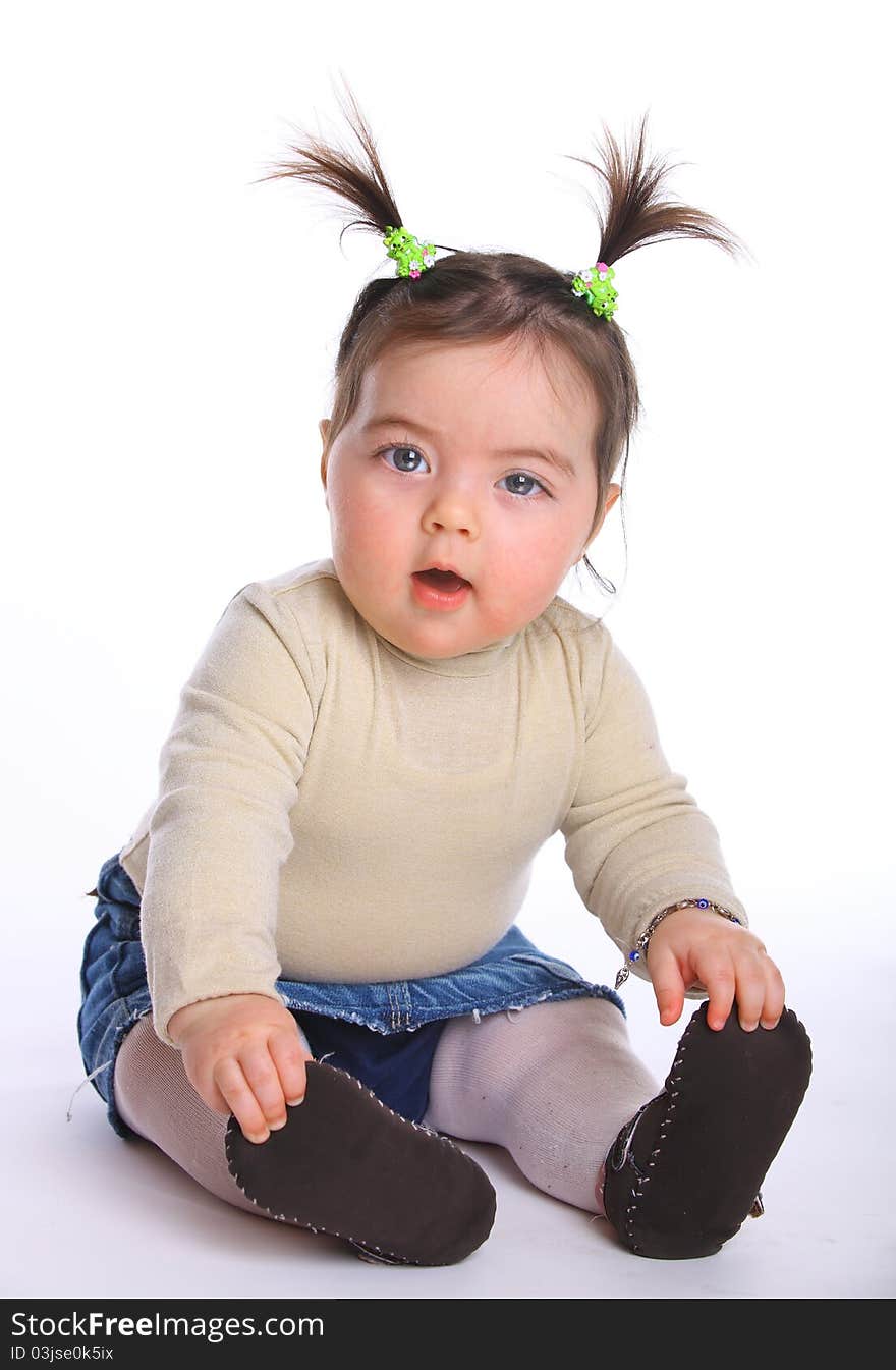 Little girl baby sitting on the floor isolated on white. Little girl baby sitting on the floor isolated on white