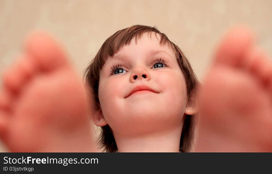 The face of the little girl against feet