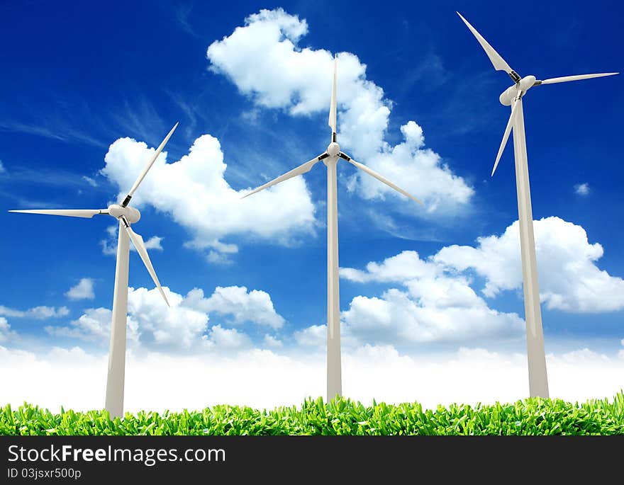 Wind turbines, green wheat fields, clouds & blue sky in spring