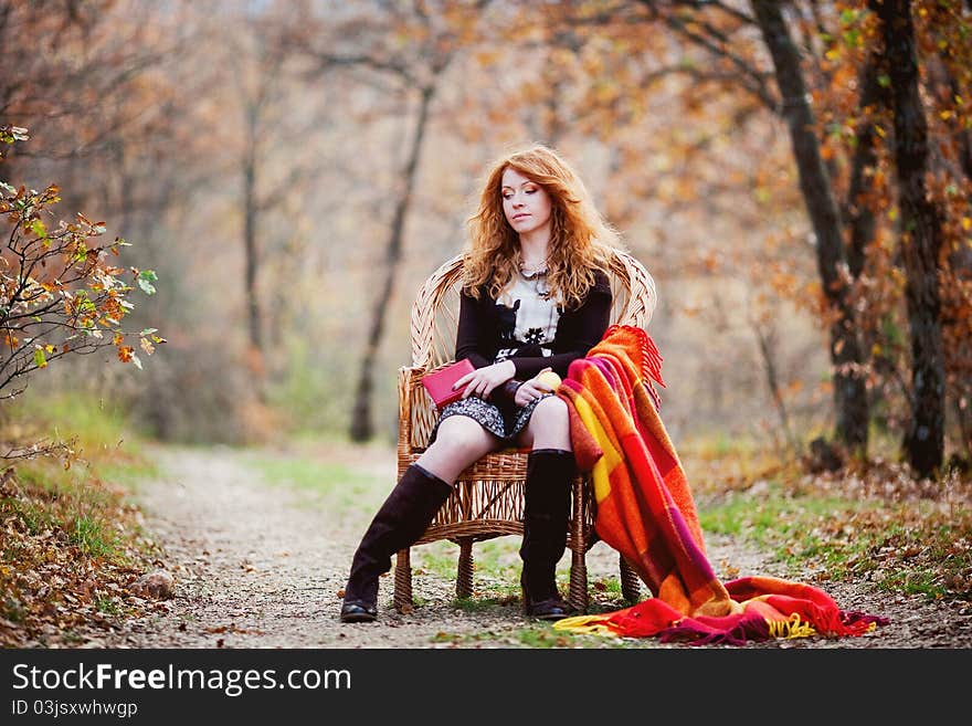 The red-haired girl in autumn leaves outdoor shot