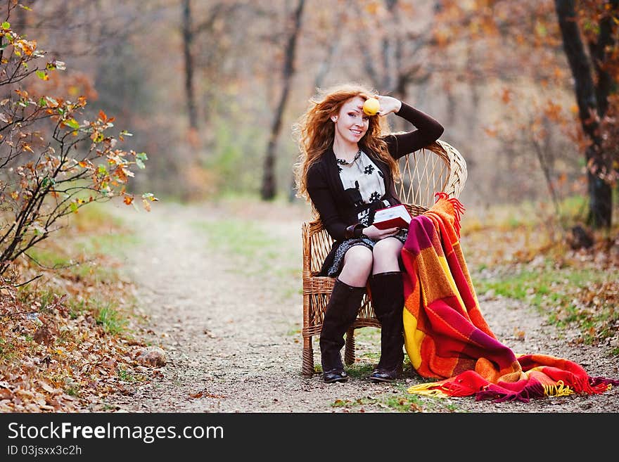 The red-haired girl in autumn leaves outdoor shot