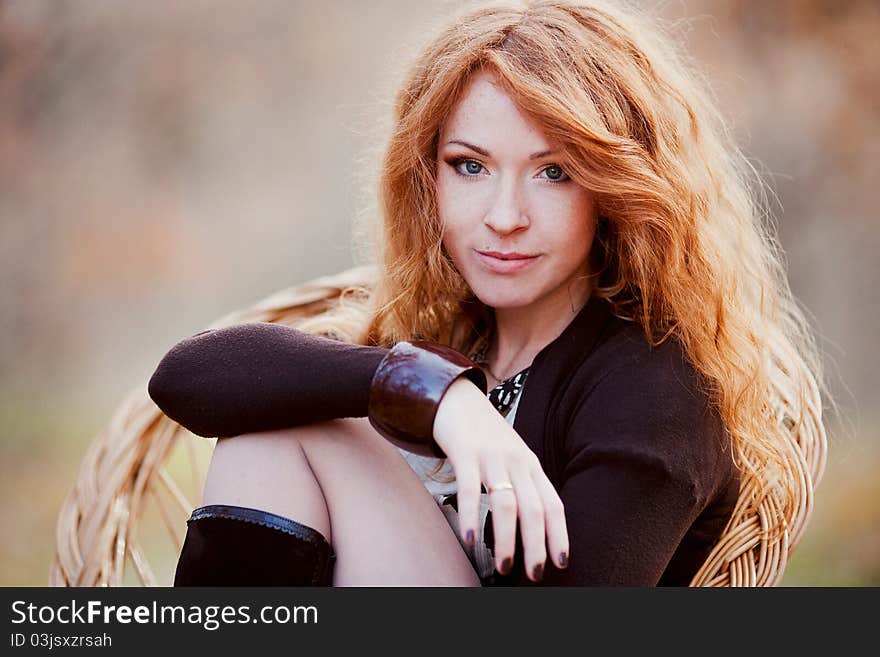 The red-haired girl in autumn leaves outdoor shot