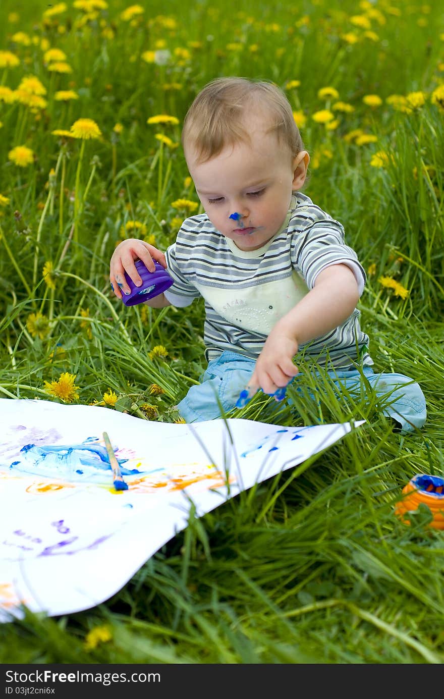 Child painting with paints on the meadow. Child painting with paints on the meadow