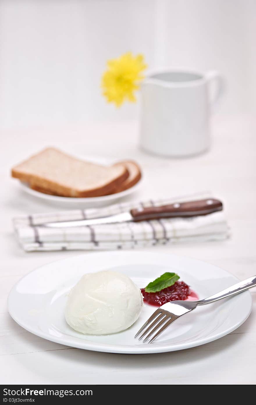 Mozzarella with cranberry sauce, in background bread and flower