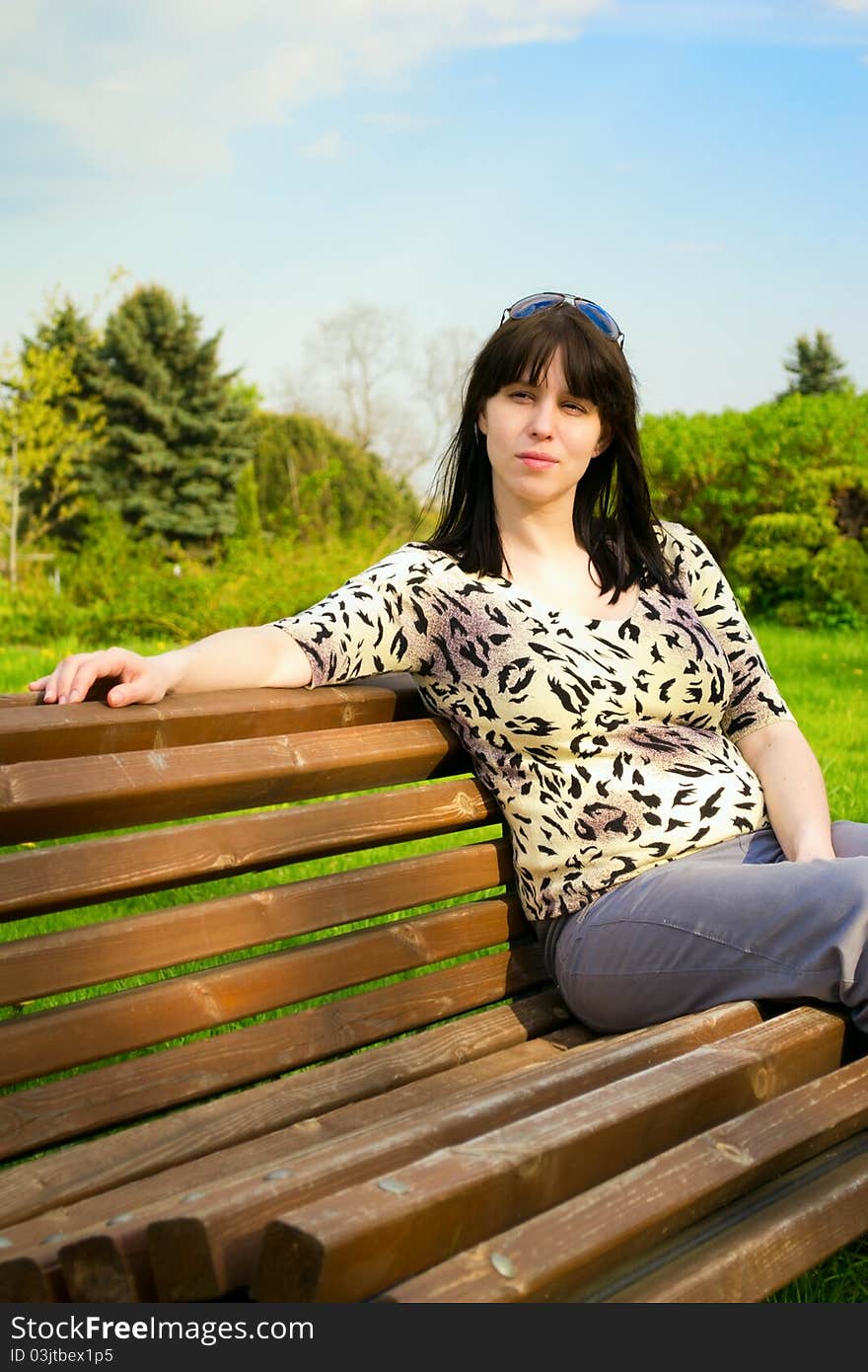 Young Woman Sits On A Bench