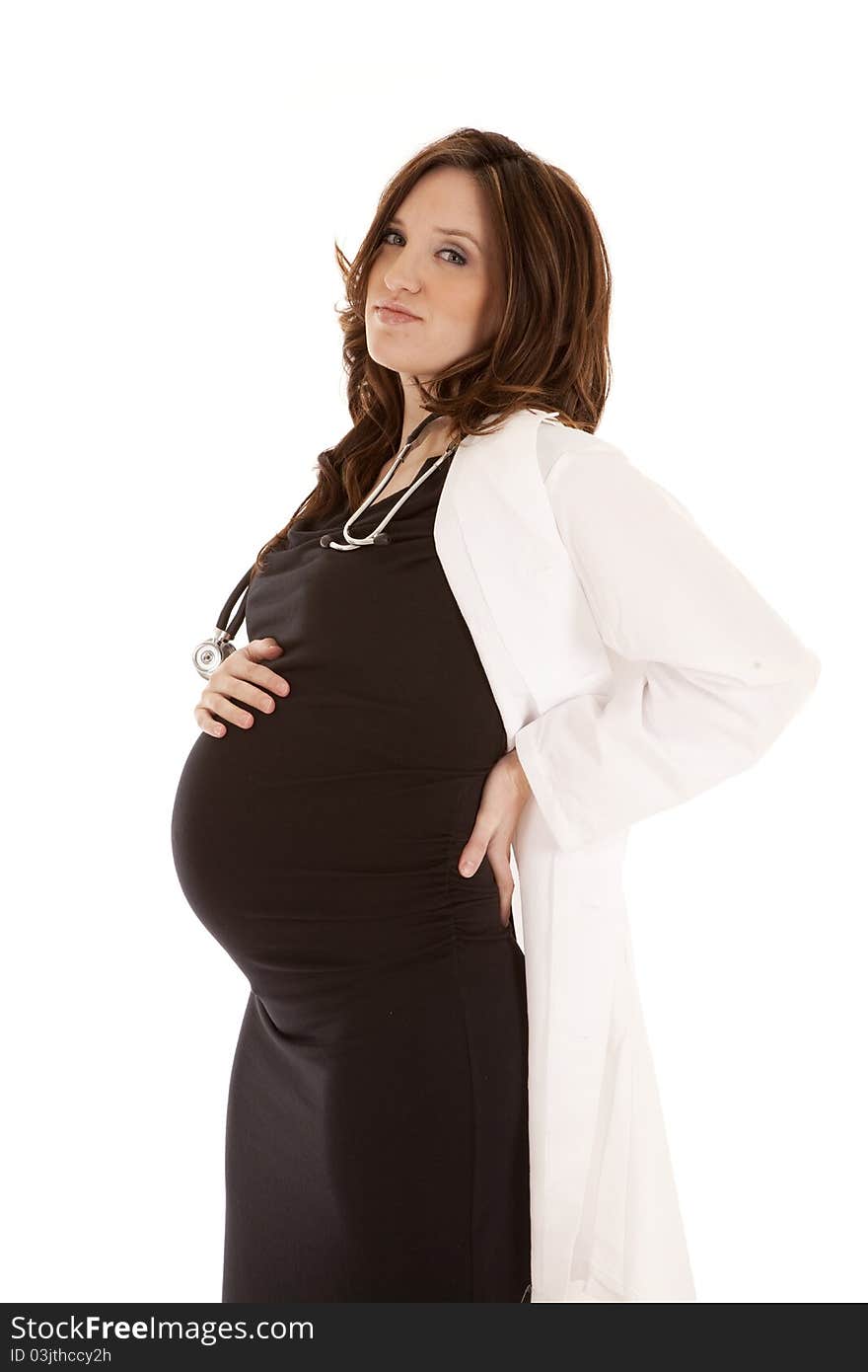 A woman doctor who is pregnant holding on to her back. A woman doctor who is pregnant holding on to her back.