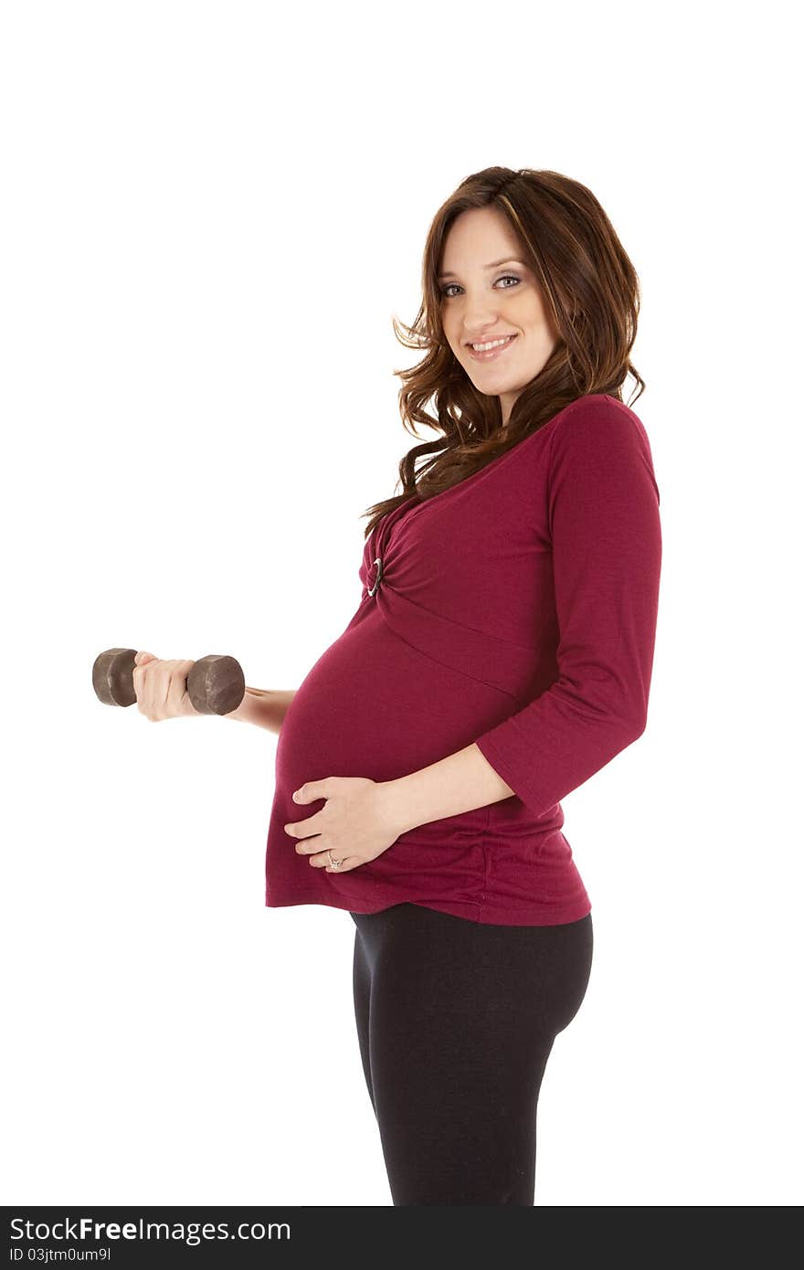 A pregnant woman working out with weights. A pregnant woman working out with weights.