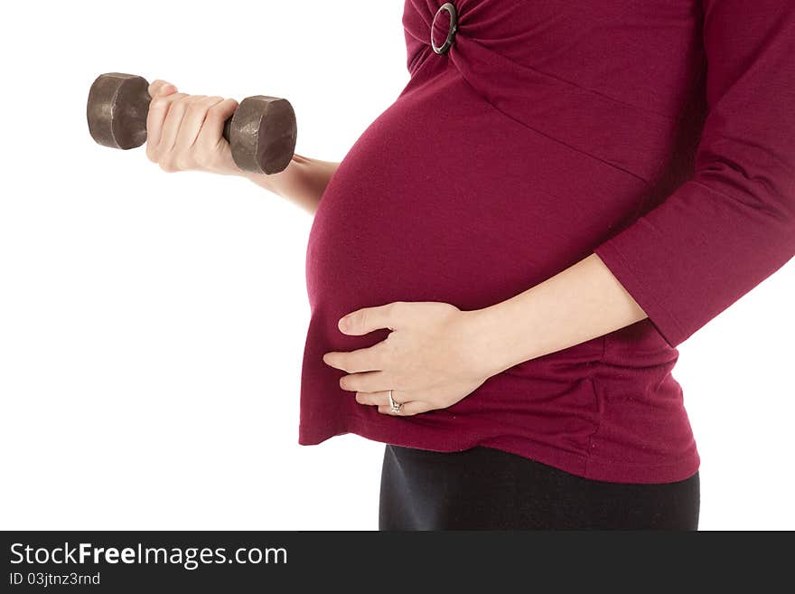 A close up of a pregnant woman working out with weights. A close up of a pregnant woman working out with weights.