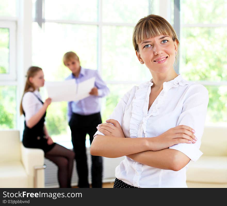 Business woman in office and collegues on background. Business woman in office and collegues on background