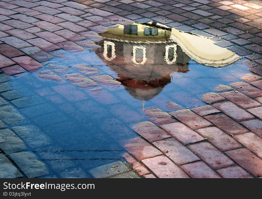 Reflection building in the puddle after rain on summer. Reflection building in the puddle after rain on summer