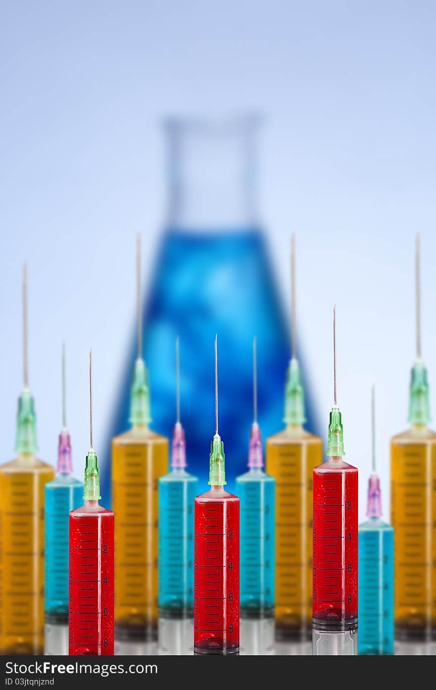 Many syringe with liquid laboratory glassware in background