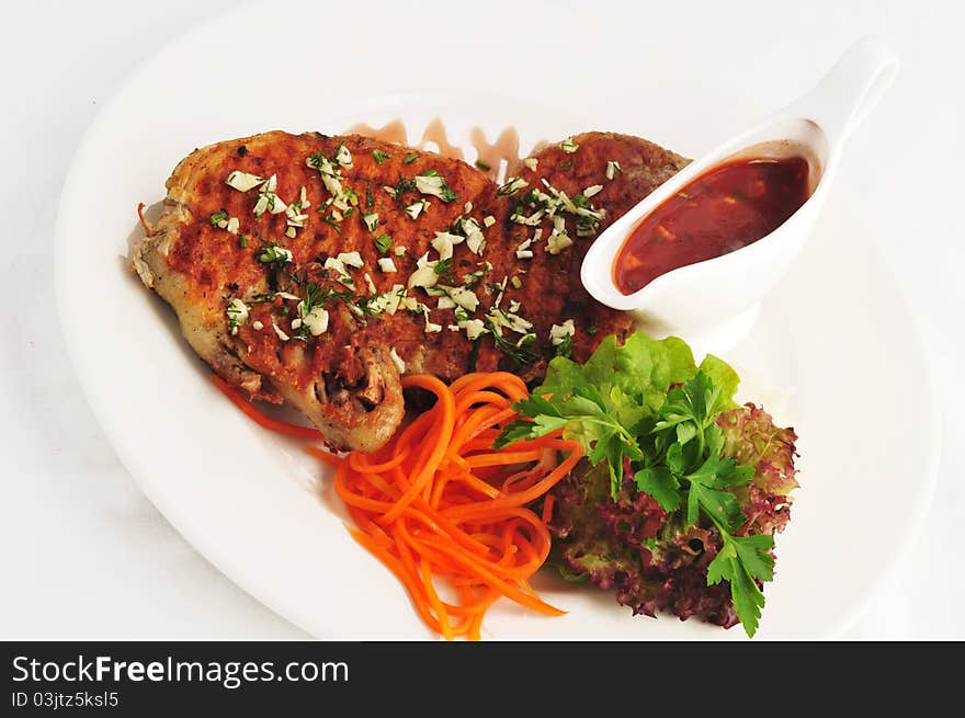 Meat on a grill with a garnish on a white plate