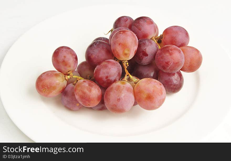 Grapes on a plate on a white background