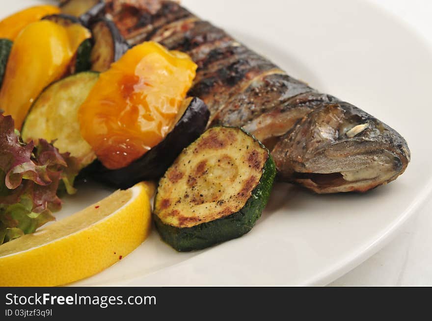 The fried fish with sauce and salad on a white plate